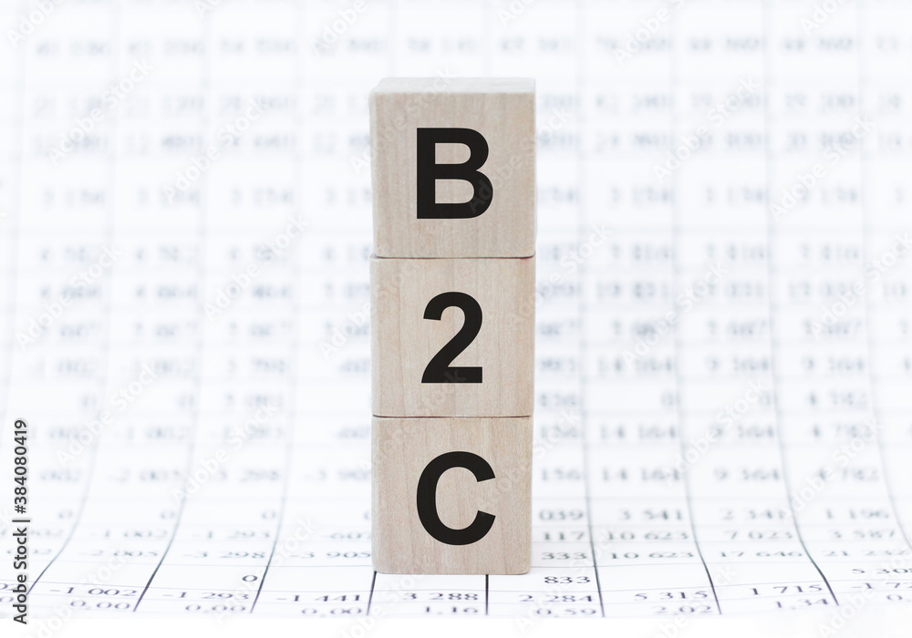 Poster b2c letters of wooden blocks in pillar form on graph background, copy space
