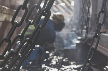 Welder doing welding on deck of merchantship for lashing cargo. 