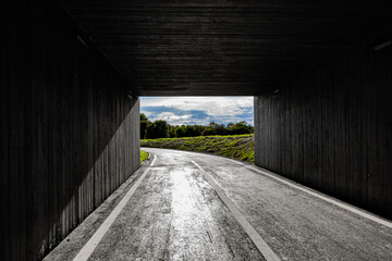 Light and landscape at the end of a dark square tunnel