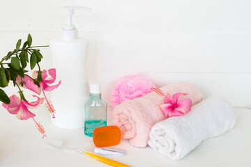 herbal liquid soap health care for body skin and mouthwash ,toothbrush ,toothpaste health care for oral cavity with terry cloth ,pink flower hibiscus arrangement flat lay style on background white 