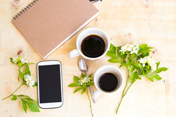 notebook planner ,mobile phone for business work and hot coffee espresso twin cup of lifestyle arrangement flat lay style on background wooden