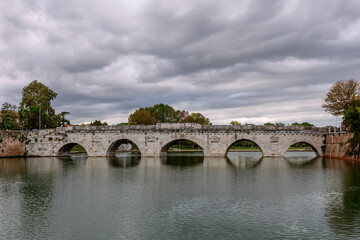 Fototapeta premium The ancient Tiberius Bridge in the historic center of Rimini, Emilia Romagna, Italy