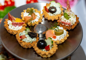 A variety of cold snacks on the table at parties, stuffed baskets with cheese and vegetables