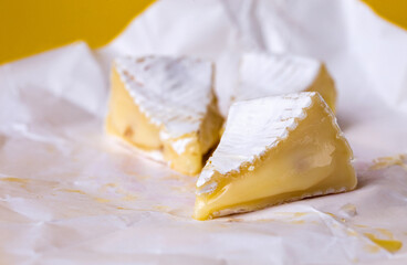  camembert cheese with honey on white paper