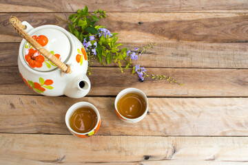 herbal healthy drinks hot tea with teapot of lifestyle relax and purple flowers arrangement flat lay style on background wooden