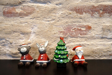Santa claus, animals and pine trees christmas day on black table brown brick background