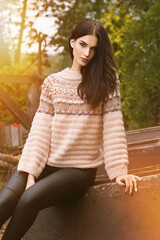 Portrait of a woman in an autumn park, in a beige knitted sweater
