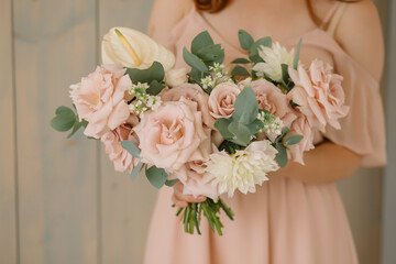 young woman florist in a pink dress with red hair holds a wedding bouquet of flowers roses
