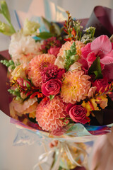 woman holding a gift bouquet of dahlias gladiolus spray rose
