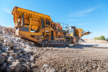 Heavy and mobile machinery in a quarry to transform stone into construction material