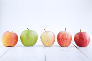 Row of different types of apples against white background