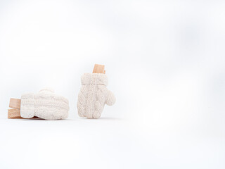 Small white winter clothes on a clothes peg for decoration on christmas and winter holidays. Close up with copy space