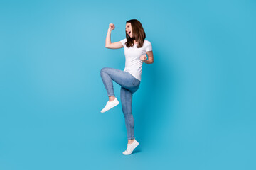 Fototapeta na wymiar Full length profile photo of attractive crazy lady good mood raise fists screaming rejoicing overjoyed football sports fan supporter wear casual white t-shirt isolated blue color background