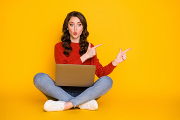 Photo of attractive shocked lady sit floor legs crossed work computer remote worker education home direct fingers empty space wear casual outfit isolated yellow color background