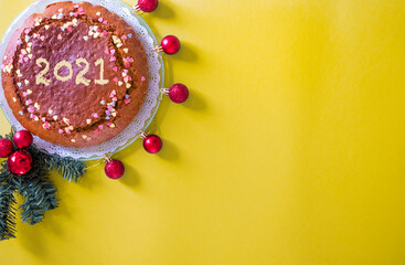 Homemade christmas cake with almonds and pumpkin on a yellow background