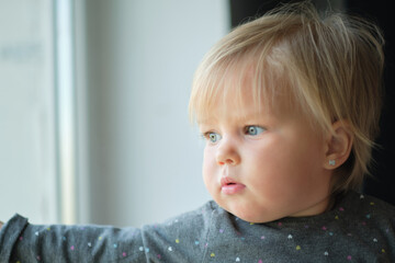 Where are you, Mom? little baby looks out the window.