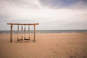 Empty swings on the beach.