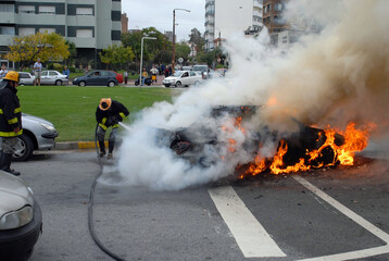 Firefighters extinguishing a car fire. Advanced stage of a fire