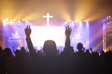 Church worship concept: Christian worship with raised hand at the at the cross cross background