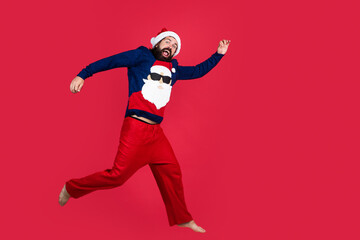 happy bearded guy in red santa claus costume running and feel happiness about christmas shopping sales, new year shopping
