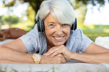 happy senior woman with headphones outdoors