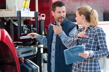 couple discussing over clipboard in farm © auremar