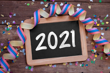 Chalkboard with four leaf clover and chimney sweeper and sparklers with happy new year 2021 on...