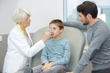 Obraz premium senior female doctor examining happy child smiling