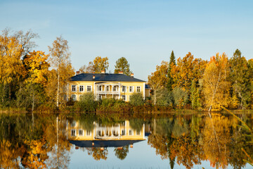 Fototapeta na wymiar Kouvola, Finland - 2 October 2020: Autumn landscape with beautiful wooden Rabbelugn Manor - Takamaan Kartano. Wrede family house was built in 1820 on the river Kymijoki bank.