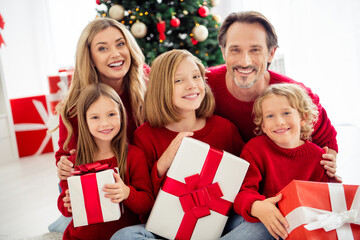 Obraz na płótnie Canvas Photo of full big family five people gathering three small kids hold present boxes toothy smile bonding atmosphere wear red jumper in home living room many x-mas gifts indoors