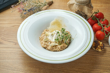 Healthy breakfast - oatmeal with poached egg, blue cheese and microgreen in a white plate.