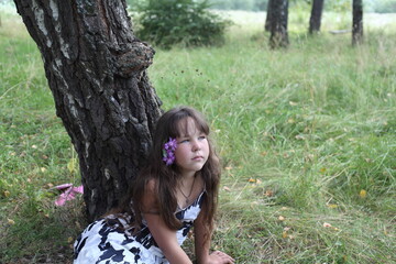 Obraz premium Girl by a birch tree in the forest