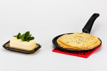 delicious pancakes on a hot frying pan and cold butter