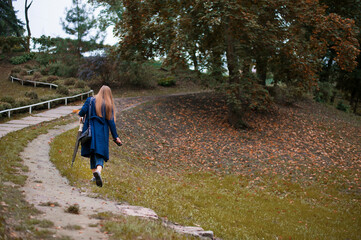 girl walking in autumn park back view