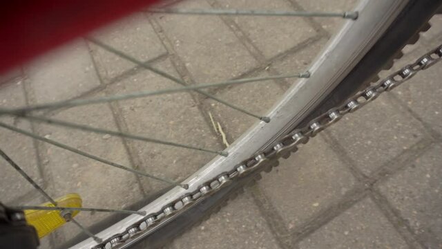 A cyclist rolls a bicycle with a flat, punctured wheel, close-up. Punched wheel tube, industry