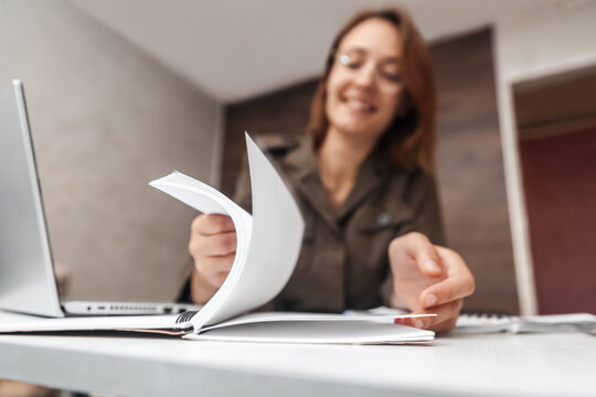 The woman flips through the pages of a notebook. Close-up