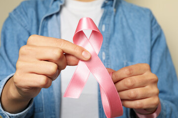 Woman hold pink awareness ribbon, close up