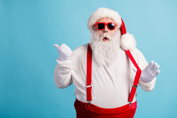 Fototapeta na wymiar Portrait of his he nice attractive amazed stunned white-haired Santa demonstrating copy space advert ad solution decision pulling suspender isolated bright vivid shine vibrant blue color background