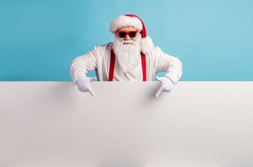 Portrait of his he nice attractive funky confident cool white-haired Santa demonstrating copy space board advice recommend look idea isolated over bright vivid shine vibrant blue color background