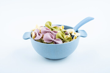 Butterfly noodles in a bowl of baby food supplement on white background
