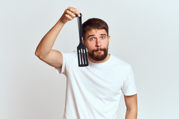 man with cooking shovel and white t-shirt close-up cropped view emotion gesturing with hand