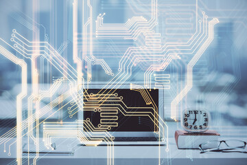 Computer on desktop in office with technology theme hologram. Double exposure. Tech concept.