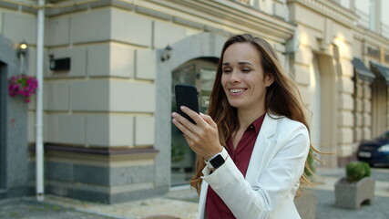 Successful business woman having video conference by phone outdoors