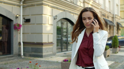 Worried businesswoman receiving bad news by mobile phone outdoors