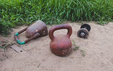 Kettlebells and dumbbell on the sand. equipment for weight lifting