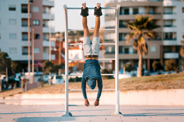 Man hanging upside down on the horizontal bar in anti gravity or inversion boots. Sports equipment. Healthy lifestyle.