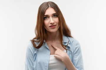 Portrait of surprised brunette girl pointing finger at herself. Face expression, negative emotions