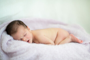 New born baby girl sleeps at home. Cute little kid's portrait
