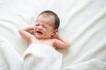 New born baby girl shouts crying in bed