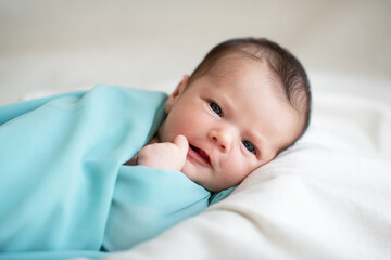 New born baby girl smiling and looking at camera. Cute little kid's portrait